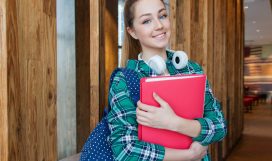 woman-standing-in-hallway-while-holding-book-1462630